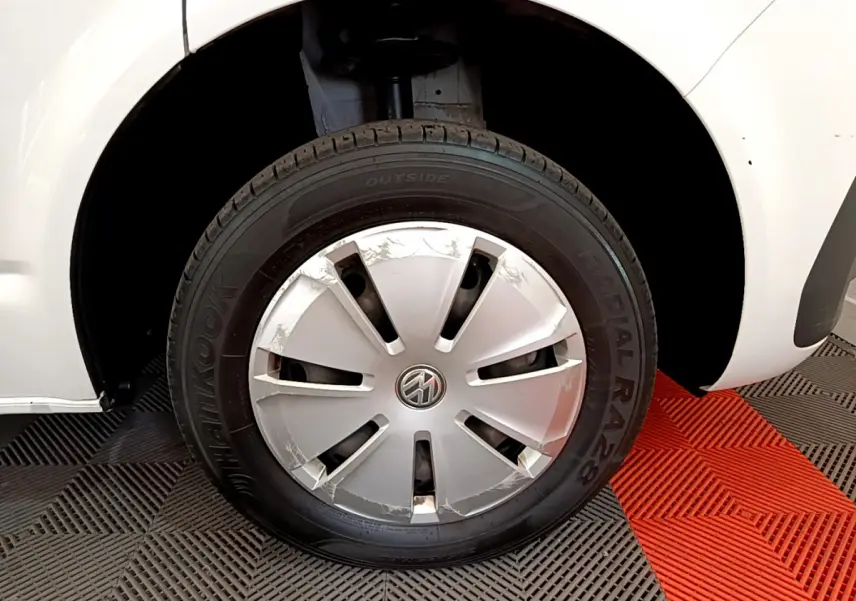 Gros plan sur la roue avant gauche blanche d'un Volkswagen Transporter 2.0 TDi 150 DSG7 avec enjoliveur abîmé.