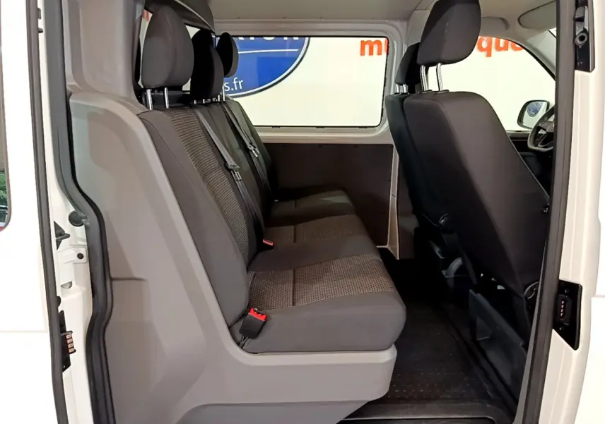 Vue intérieure côté droit du Volkswagen Transporter blanc 2021, banquette arrière trois places en tissu gris.