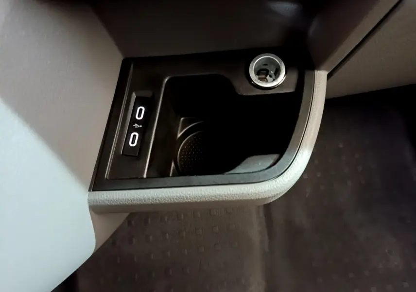 Prise 12V et double port USB intégrés dans la console inférieure côté passager du Volkswagen Transporter blanc.