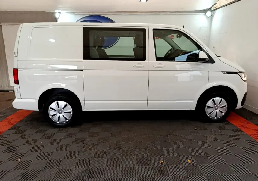 Vue latérale droite d'un Volkswagen Transporter blanc 2021 avec vitres avant et arrière côté passager.