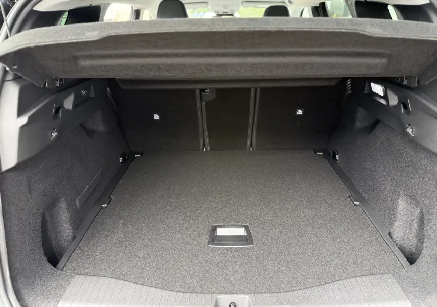 Vue intérieure du coffre spacieux et propre du Citroën C5 Aircross hybride 2026, avec cache-bagages relevé.