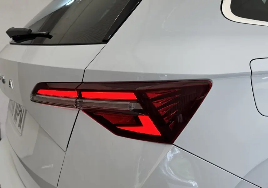 Gros plan sur le feu arrière droit rouge allumé d’un SKODA KAROQ blanc, vue arrière côté droit.