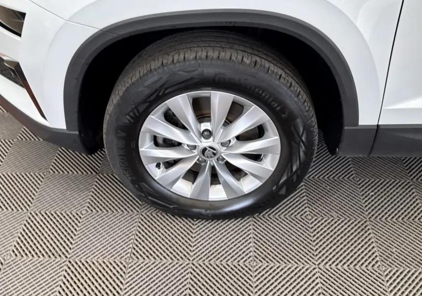 Gros plan sur la roue avant gauche blanche du Skoda Karoq 2024 avec jante alliage et pneu Continental.