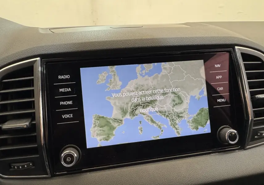 Écran tactile central du tableau de bord du Skoda Karoq 2024 affichant une carte de navigation en mode boutique.