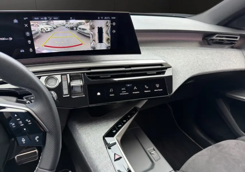 Vue intérieure du tableau de bord gris clair du Peugeot 5008 2025 avec écran tactile multifonctions et volant partiel visible.