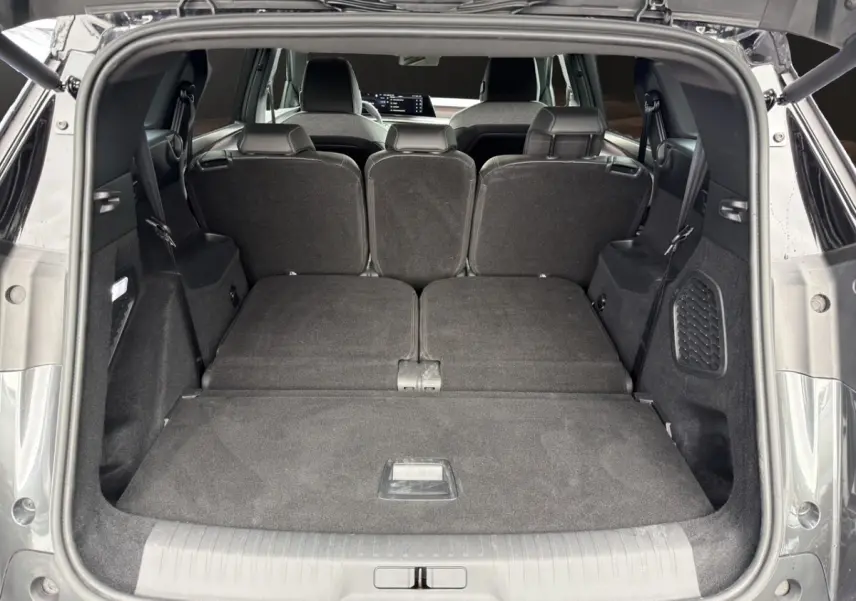 Coffre ouvert du Peugeot 5008 gris foncé, vue arrière montrant la 3ème rangée de sièges rabattue et l'espace de chargement.