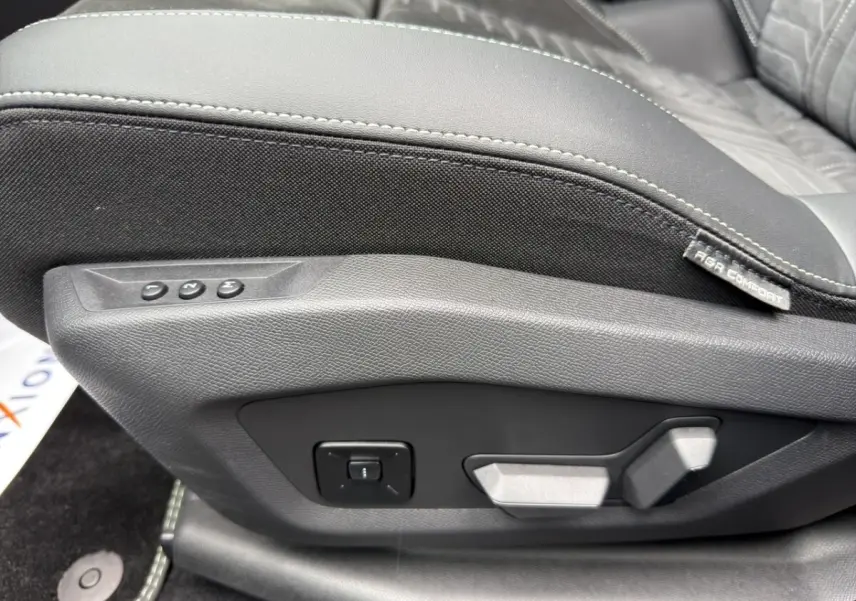 Gros plan sur les commandes de réglage électrique du siège avant en cuir noir et tissu gris du Peugeot 5008 2025.