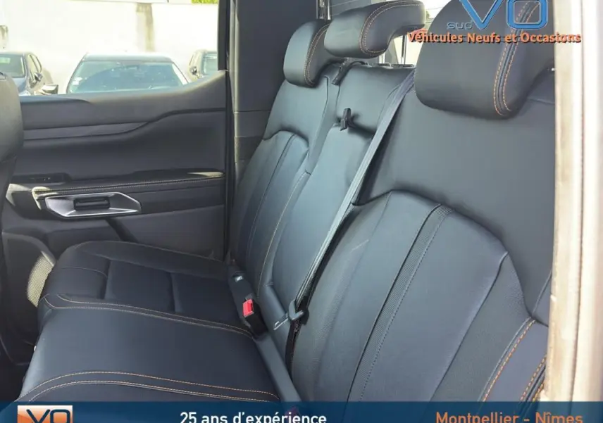 Vue intérieure sur la banquette arrière en cuir noir avec surpiqûres orange du Ford Ranger Wildtrak 2025.