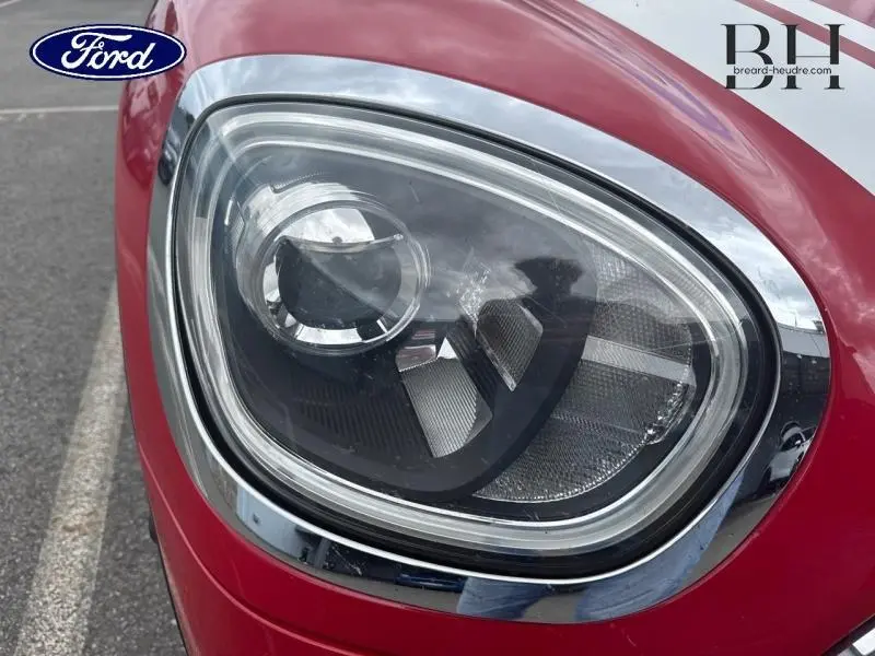 Gros plan sur le phare avant droit chromé d'une MINI Countryman Cooper D 150ch Chili Red de 2018.