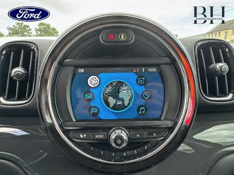 Tableau de bord central d’un MINI Countryman Chili Red 2018, écran multifonction entouré d’un anneau lumineux rouge.