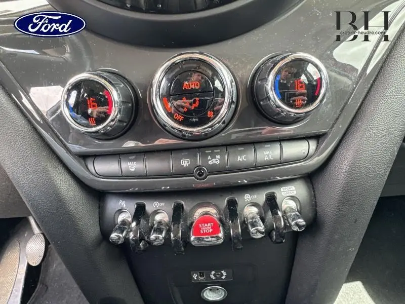 Gros plan sur la console centrale de la MINI Countryman Chili Red 2018, montrant les commandes de climatisation et le bouton Start/Stop rouge.