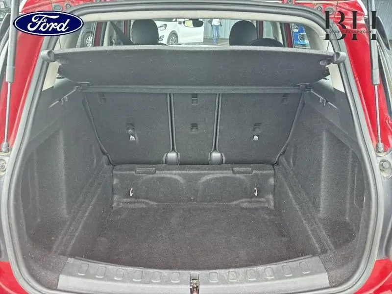 Coffre ouvert vu de l'arrière d'une MINI Countryman Chili Red, montrant l'espace de chargement et la banquette arrière.