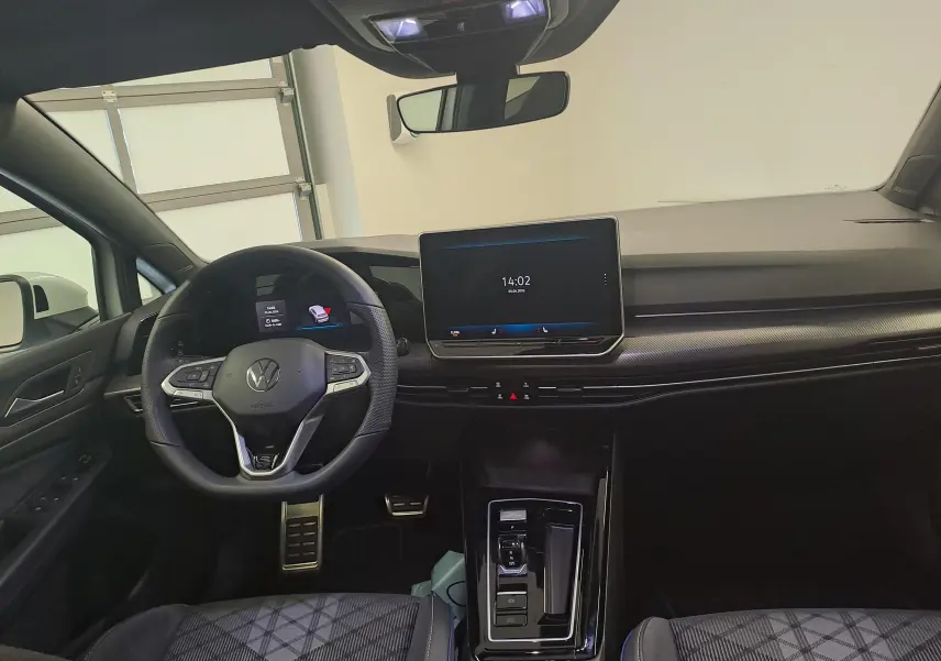 Vue intérieure avant de la Volkswagen Golf 2.0 TDI 150 DSG7 avec tableau de bord moderne et volant multifonction en cuir.
