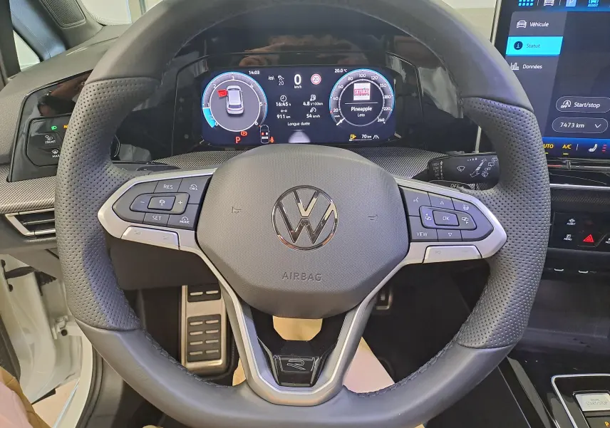 Vue rapprochée du volant en cuir perforé de la Volkswagen Golf 2.0 TDI blanc Oryx avec tableau de bord numérique.