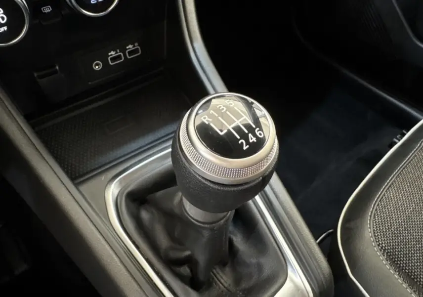 Gros plan sur le levier de vitesses manuel noir du Renault Captur Techno TCe 90, intérieur avec console centrale noire.