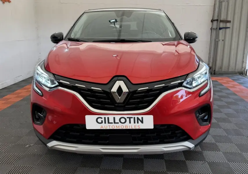Vue frontale d'un Renault Captur rouge 2024 avec calandre noire et détails chromés, phares LED allumés.