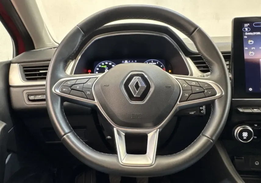 Vue centrée sur le volant noir du Renault Captur 2024 avec tableau de bord numérique et écran tactile central.