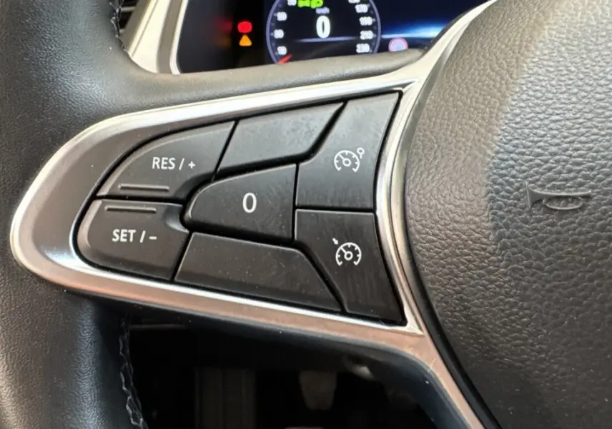 Gros plan sur les commandes de régulateur de vitesse au volant noir du Renault Captur Techno TCe 90 2024.