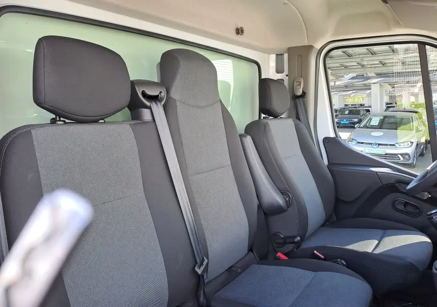 Vue intérieure côté droit montrant les sièges avant gris et noirs du Nissan Interstar Châssis Cabine blanc 2024.
