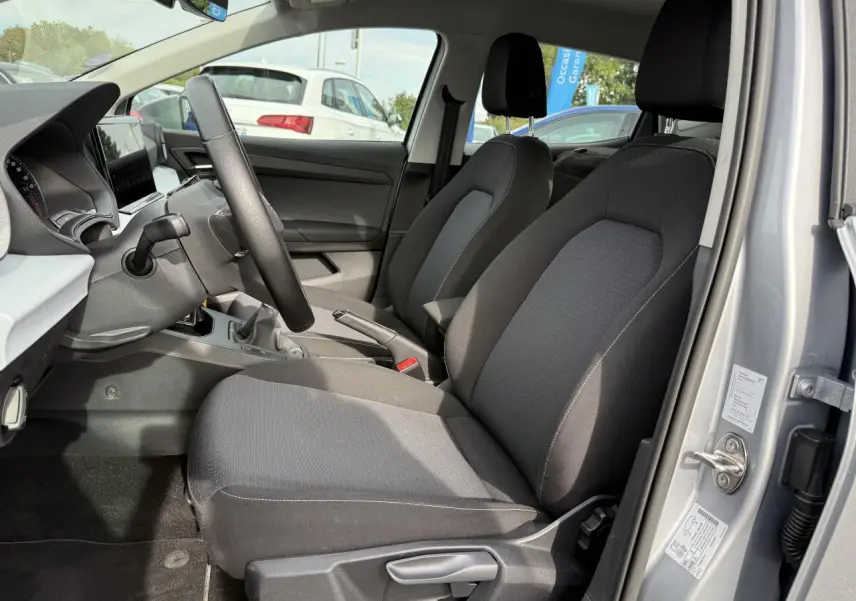 Intérieur avant droit d'une SEAT Ibiza 1.0 TSI Style argent Urban, sièges tissu noir et tableau de bord moderne.