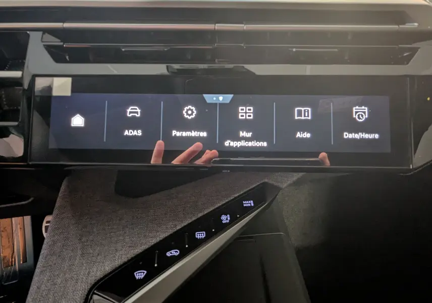 Vue rapprochée de l’écran tactile central du Peugeot 3008 Hybrid 145 GT avec interface en français et tissu gris sur la console.