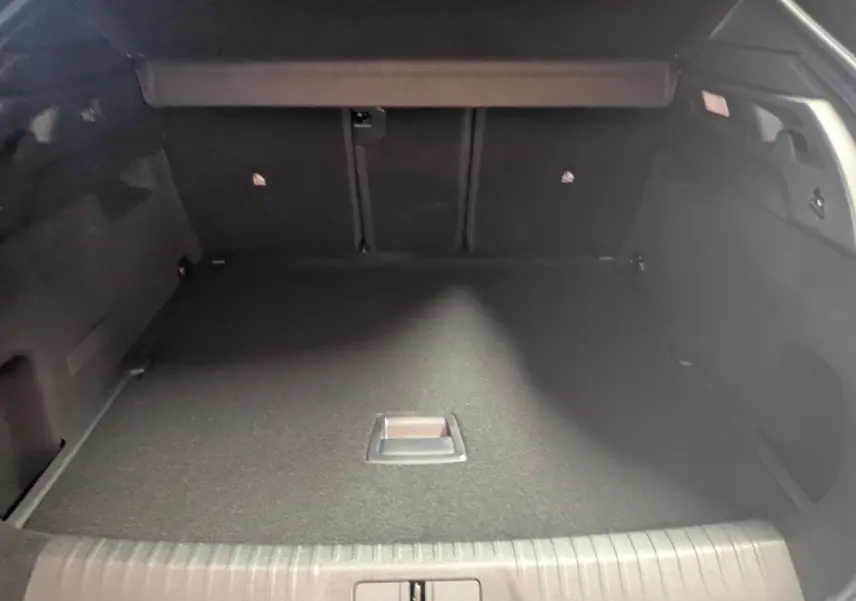 Vue intérieure du coffre spacieux et vide du Peugeot 3008 Hybrid 145 GT, avec revêtement noir uniforme.