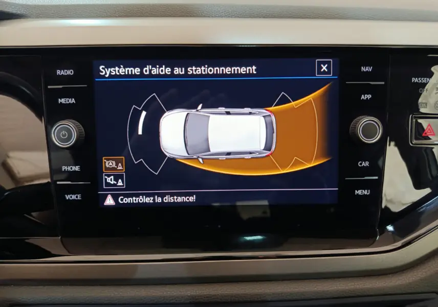 Écran tactile intérieur affichant le système d'aide au stationnement de la Volkswagen Polo blanche 2020.