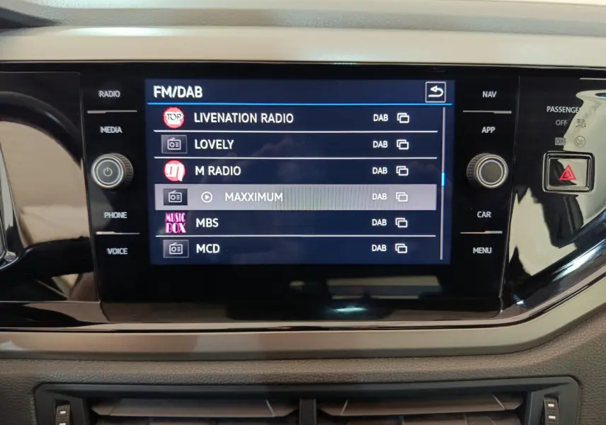 Écran tactile central affichant les stations radio DAB dans l'habitacle d'une Volkswagen Polo blanche 2020.