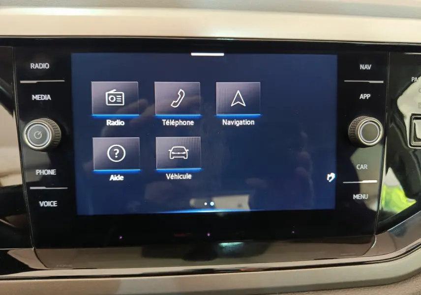 Écran tactile central affichant les options radio, téléphone, navigation et véhicule dans un Volkswagen Polo blanc de 2020.