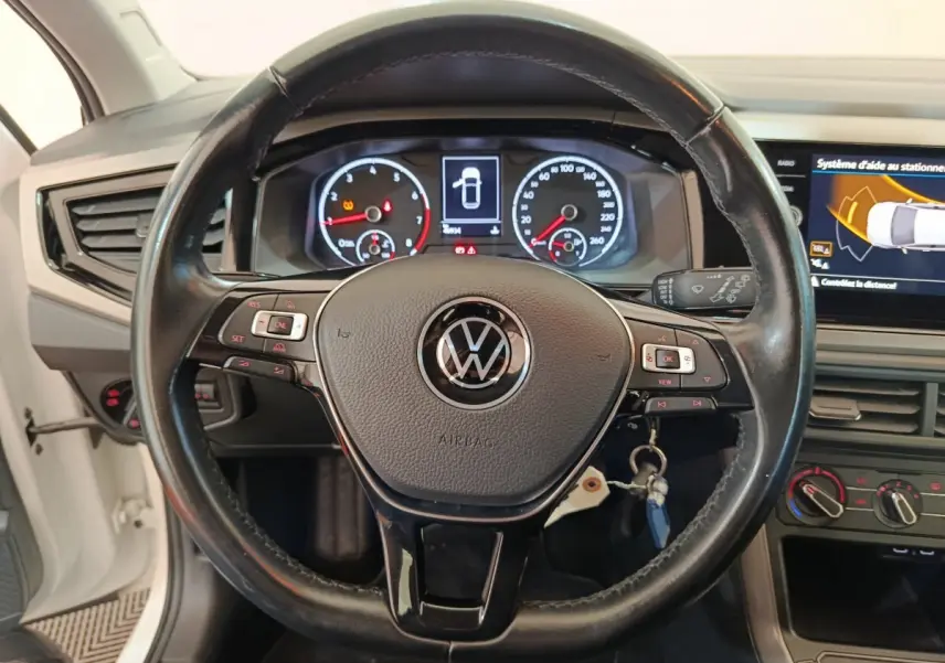 Vue rapprochée du volant en cuir noir de la Volkswagen Polo 2020 avec tableau de bord numérique et écran tactile.