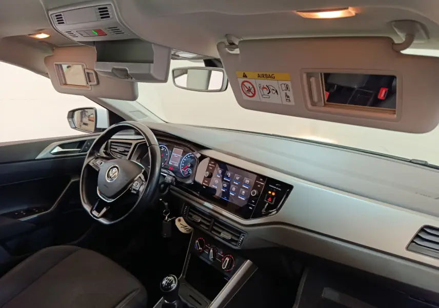 Intérieur avant droit de la Volkswagen Polo blanche 2020, tableau de bord avec écran tactile et volant cuir multifonctions.