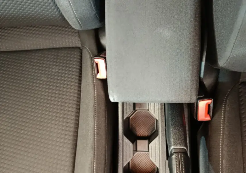 Vue plongeante sur la console centrale noire et les sièges tissu gris foncé de la Volkswagen Polo 2020 blanche.