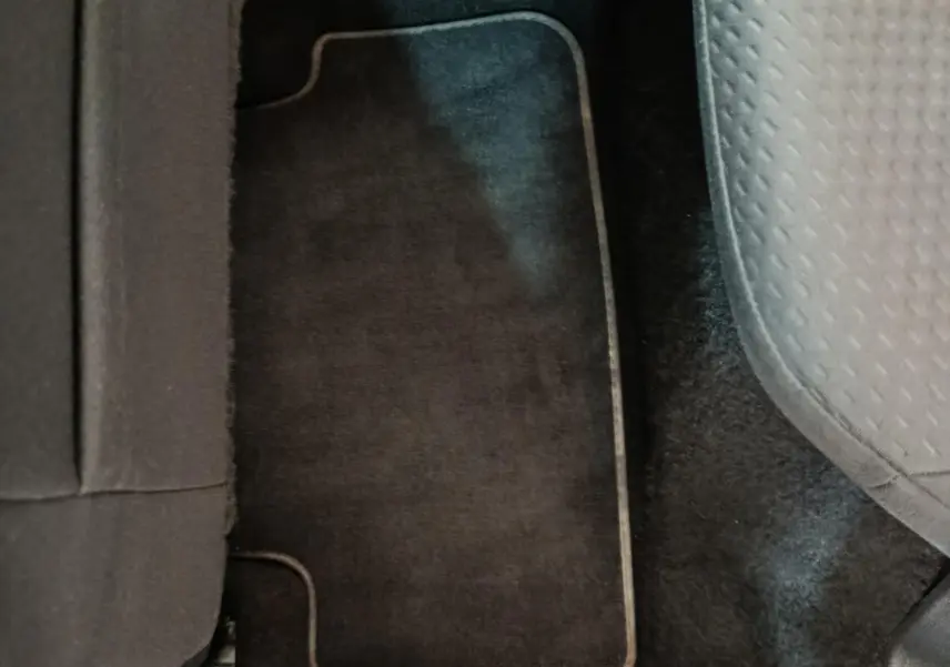 Vue rapprochée du tapis de sol noir et siège tissu gris côté droit arrière d'une Volkswagen Polo blanche 2020.