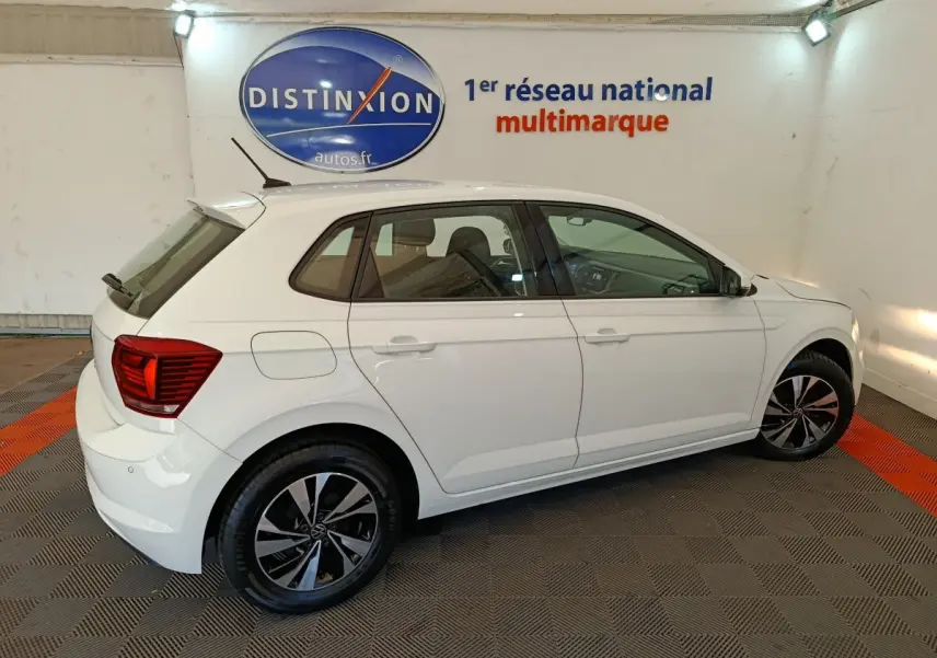 Volkswagen Polo blanche vue de profil côté gauche dans un showroom avec jantes alliage et feux arrière rouges.