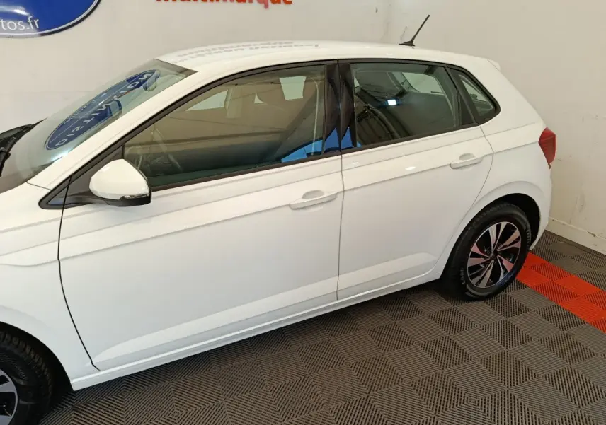 Profil droit d'une Volkswagen Polo blanche 2020, avec jantes alliage et rétroviseur blanc intégrant un clignotant.