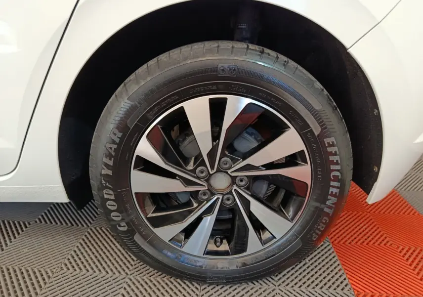 Gros plan sur la roue arrière droite d'une Volkswagen Polo blanche, avec partie de la carrosserie visible.