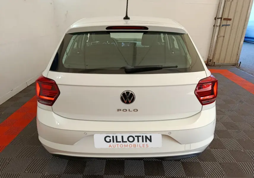 Vue arrière d'une Volkswagen Polo blanche 2020 avec feux arrière rouges et logo VW visible.