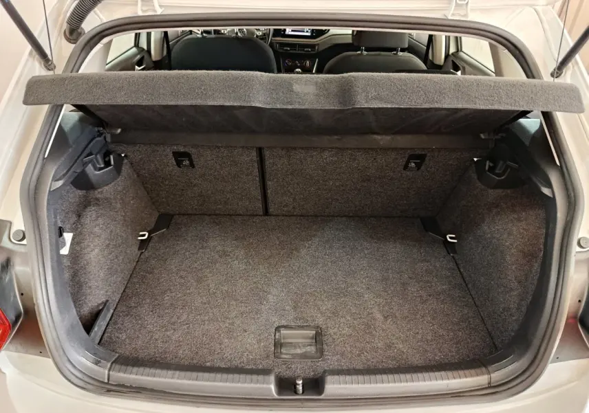 Coffre ouvert vu de l'arrière d'une Volkswagen Polo blanche 2020, montrant l'espace de rangement et la tablette amovible.