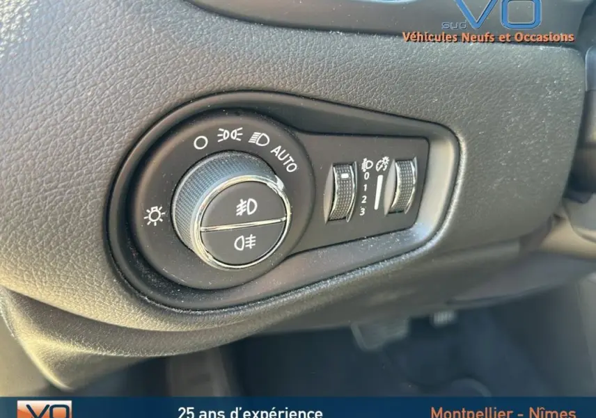 Gros plan sur la molette de réglage des phares et des feux antibrouillard du tableau de bord du Jeep Renegade noir 2024.