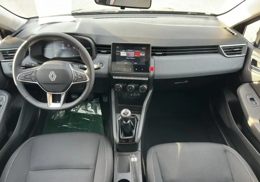 Vue intérieure avant de la Renault Clio DCI 100 Evolution Camera 2025, tableau de bord gris, volant cuir multifonctions et boîte manuelle.