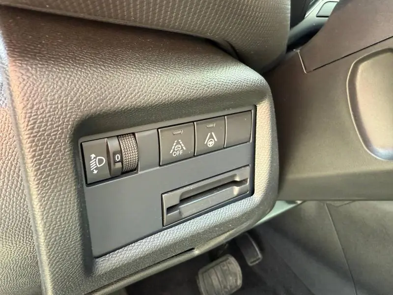 Vue rapprochée des commandes noires à gauche du volant du Citroën C5 Aircross 2025, avec réglage phares et aides à la conduite.