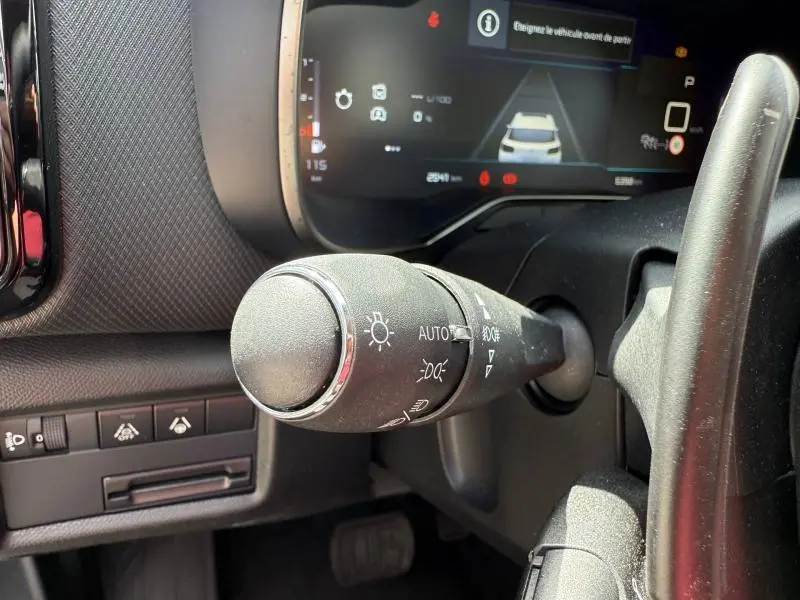 Gros plan sur la commande des feux à gauche du volant dans le cockpit du Citroën C5 Aircross 2025 hybride.