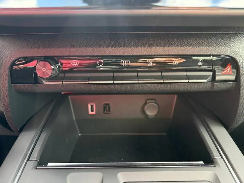 Vue rapprochée de la console centrale noire du Citroën C5 Aircross 2025, montrant les commandes climatisation et ports USB.