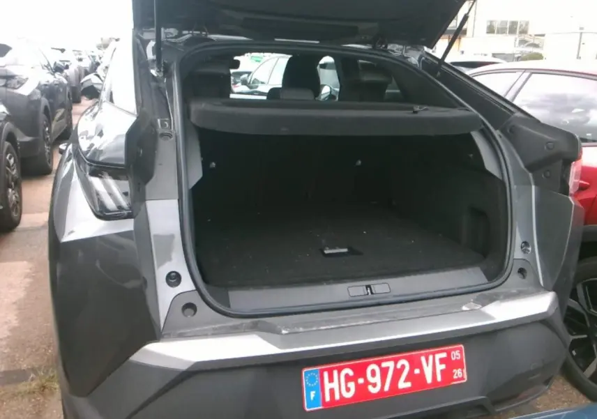 Vue arrière ouverte du Peugeot 3008 gris foncé 2025, mettant en valeur le coffre spacieux et la finition métallique.