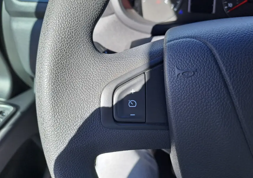 Gros plan sur le volant noir du Nissan Interstar Chassis Cabine 2024, bouton de réglage d'intensité lumineuse visible.