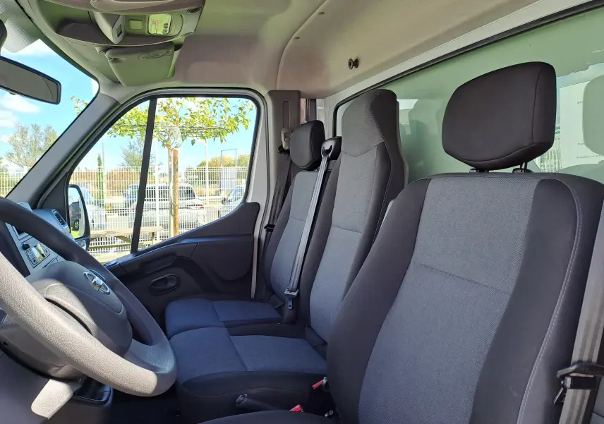 Vue intérieure côté conducteur du Nissan Interstar L3H1 2024, montrant les sièges gris et noirs et le volant.