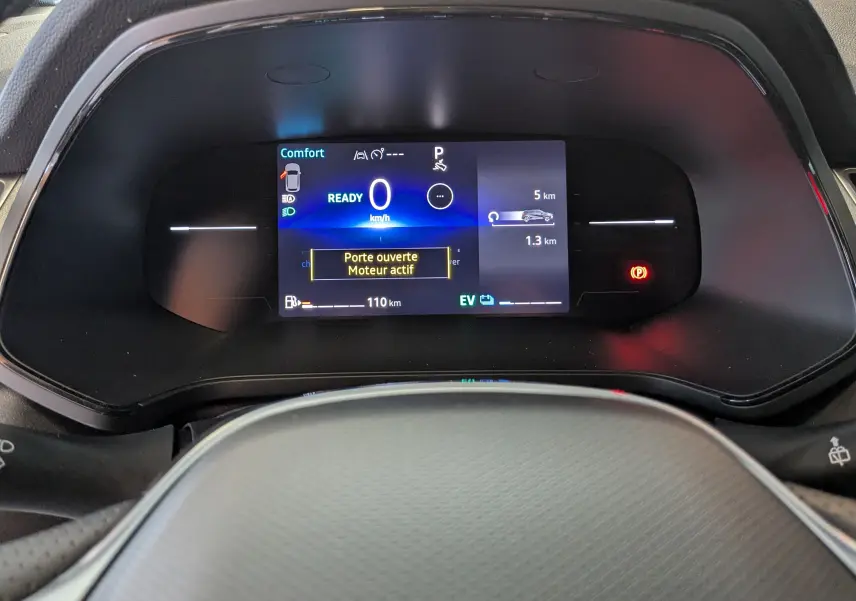 Tableau de bord numérique du Renault Captur E-Tech 2025, affichant vitesse zéro et message porte ouverte.