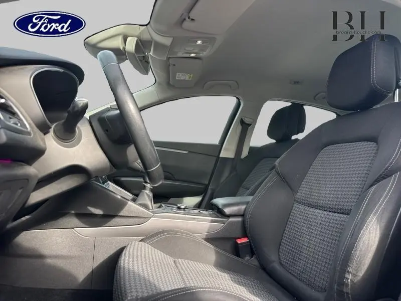 Intérieur avant droit d'une Renault Talisman gris cassiopée, volant cuir multifonction et sièges tissu noir.