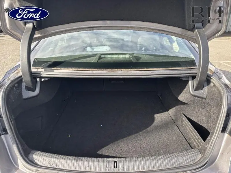 Coffre ouvert d'une Renault Talisman gris Cassiopée, vue arrière montrant l'espace de rangement intérieur.