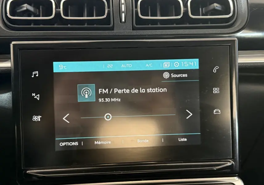Écran tactile central affichant la radio FM dans l'habitacle noir d'une Citroën C3 gris clair, vue de face.